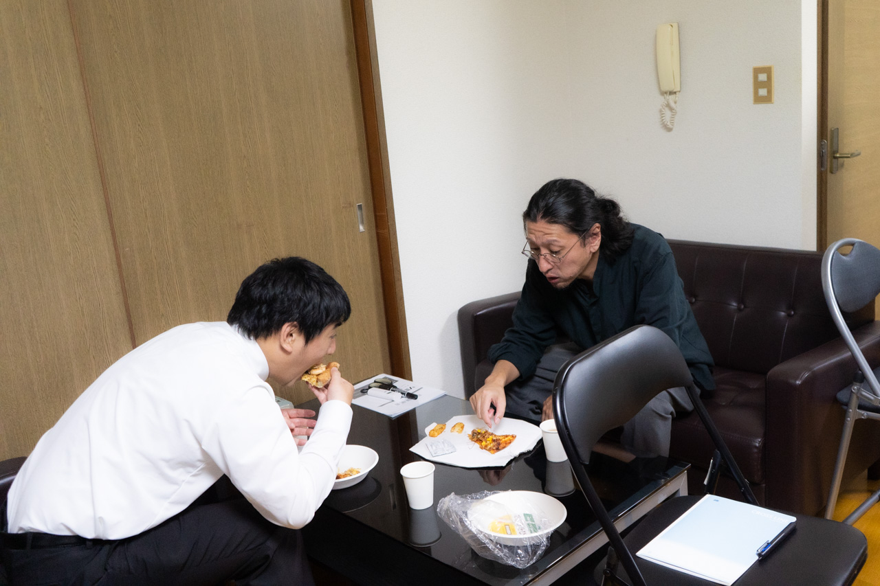 黙々とピザを食べる社員たち